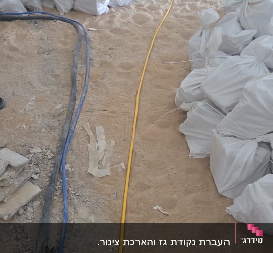 שקי חול וצינורות באתר בנייה